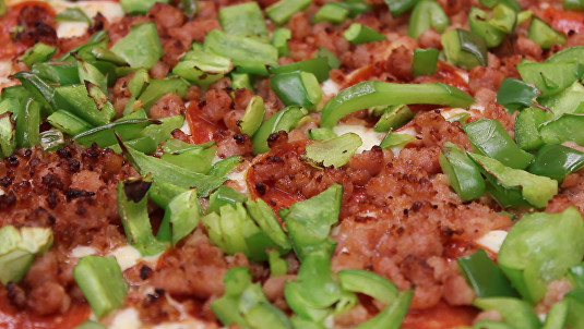 cooked pizza with green peppers